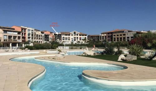 - une piscine dans un complexe avec des bâtiments en arrière-plan dans l'établissement Appartement cosy climatisé à 100m des plages, à Gassin