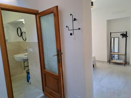 La salle de bains est pourvue d'une porte en bois et d'un lavabo. dans l'établissement Affittacamere Sophie, à Monterosso al Mare