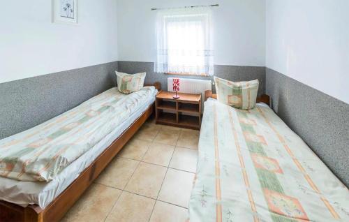 two beds in a small room with a window at Amazing Apartment In Tumiany With Wifi in Tumiany