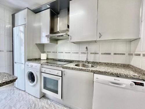 uma cozinha branca com um lavatório e uma máquina de lavar louça em Vivienda con Parking incluido - Zona Van Dyck em Salamanca