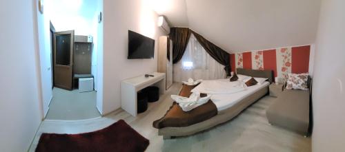 um pequeno quarto com uma cama e uma televisão em Casa Diana em Sulina