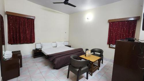 a bedroom with a bed and a table and chairs at Hotel President in Gorakhpur