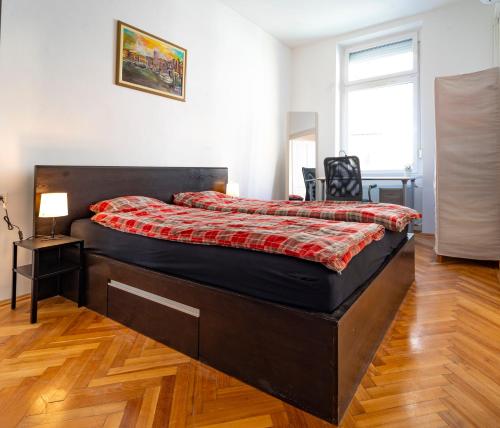 een slaapkamer met een groot bed en een rode deken bij Anett's downtown apartment in Boedapest