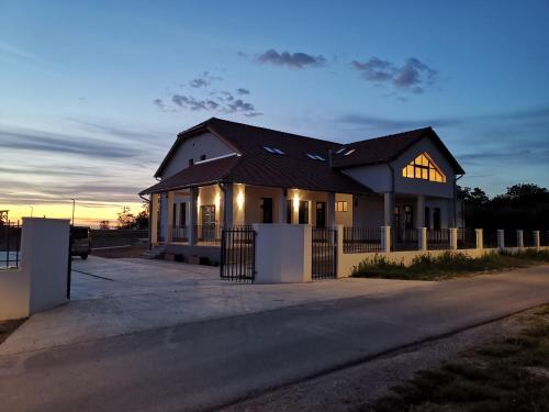 a house on a street with the sunset in the background at La Vida Panorama in Batina