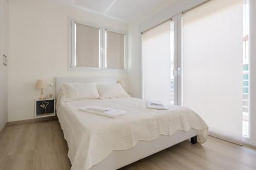 a white bedroom with a large bed with white sheets at Mylarakia in Chios