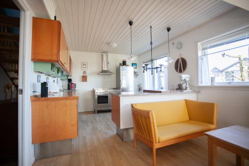 une cuisine avec une chaise jaune et un comptoir dans l'établissement Apartments - 20 min walk from city centre, à Tórshavn