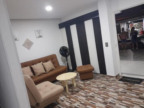 ein Wohnzimmer mit einem Sofa und einem Tisch in der Unterkunft Hanna's House. in Villavicencio