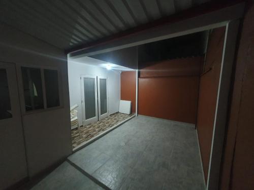 een lege kamer met rode muren en een hal bij Hanna's House. in Villavicencio