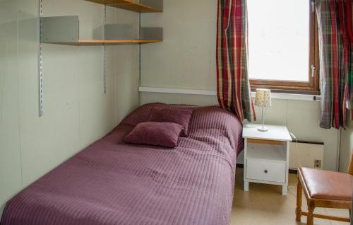 ein violettes Bett in einem Schlafzimmer mit einem Fenster in der Unterkunft 2 Bedroom Stunning Home In Skotterud in Magnor