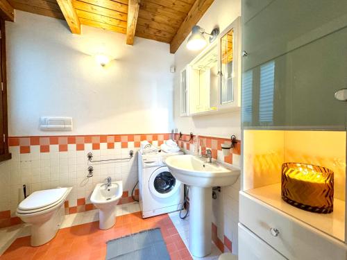 La salle de bains est pourvue d'un lavabo et d'un lave-linge. dans l'établissement Villa Riflessi - Manerba del Garda, à Manerba del Garda