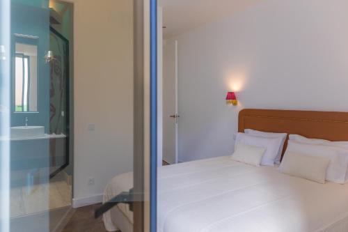 a bedroom with a bed with a mirror and a sink at Canto 18 in Salir de Porto