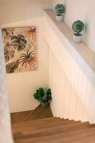 a staircase with potted plants and a painting on the wall at Mylarakia in Chios