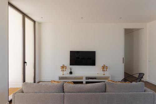 a living room with a couch and a tv on a wall at Canto 18 in Salir de Porto