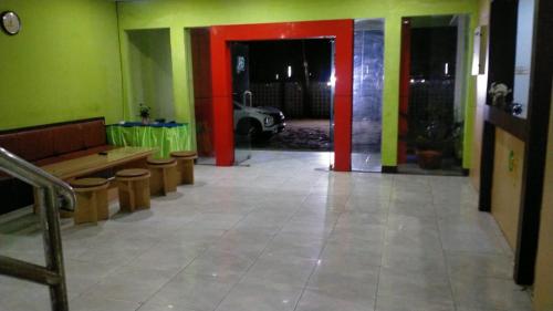um quarto com paredes verdes e vermelhas e um banco em Hotel Grand Atlet Bengkulu em Bengkulu