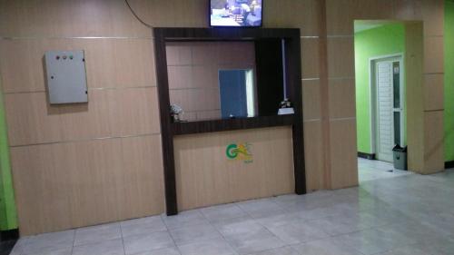 a room with a wall with a tv on it at Hotel Grand Atlet Bengkulu in Bengkulu