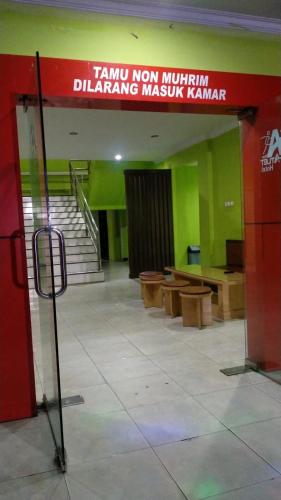 a room with a staircase and benches in a building at Hotel Grand Atlet Bengkulu in Bengkulu