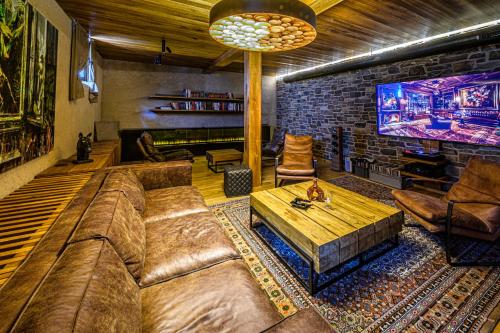 a living room with a couch and a tv at DOMA u nás Boutique hotel & spa in Poprad