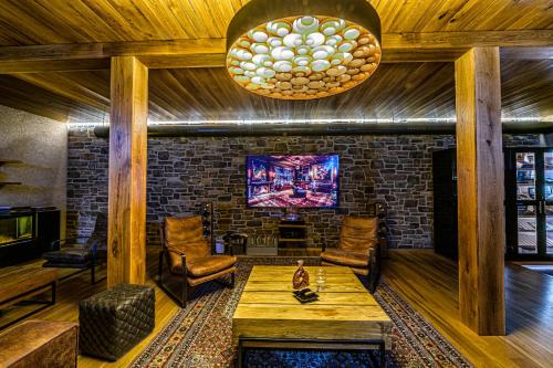 a living room with a table and chairs and a tv at DOMA u nás Boutique hotel & spa in Poprad