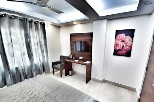 um quarto com uma secretária e uma cadeira com uma flor na parede em Hotel Delhi Aerocity, NH 8 em Nova Deli