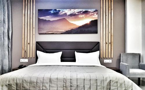 a bedroom with a bed and a painting on the wall at Hotel Delhi Aerocity, NH 8 in New Delhi