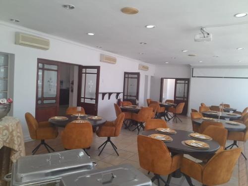 a restaurant with tables and chairs in a room at Sapphire Hotel Halevy Heritage in Bloemfontein