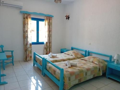 1 dormitorio con 2 camas y ventana en Residence Gerani, en Agios Nikolaos