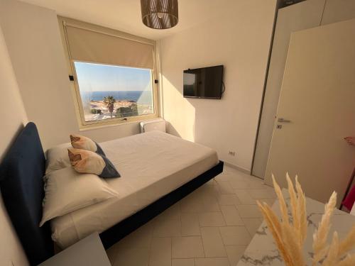 a small bedroom with a bed and a window at Puglia Dreaming seaview apartment in Polignano a Mare