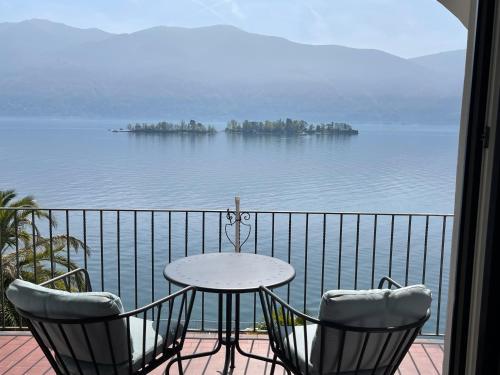 a table and chairs on a balcony with a view of the water at Residenza Bettina BnB & Ferienwohnungen in Ronco s/Ascona - Porto Ronco
