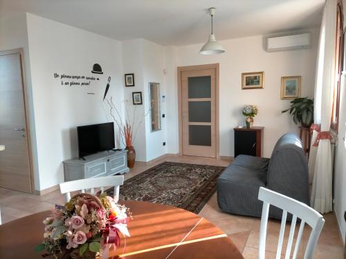 uma sala de estar com um sofá e uma televisão em CASA ELGA em Borgo a Buggiano