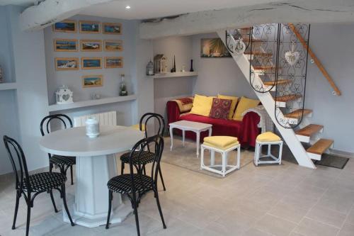 ein Wohnzimmer mit einem Sofa, einem Tisch und Stühlen in der Unterkunft Gite de la rampotiere in Quettreville-sur-Sienne