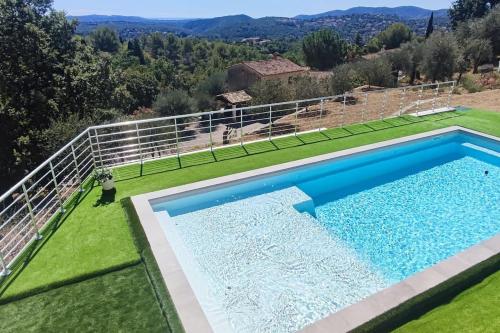 - une vue sur la piscine dans une cour avec gazon dans l'établissement Villa piscine et jacuzzi la madonnette, à Spéracèdes