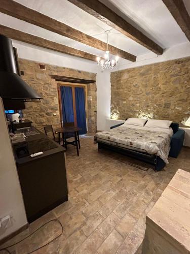 a bedroom with a bed and a table in a room at Borgo di Mezzo in Castelnuovo dellʼAbate