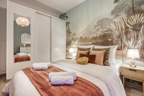 une chambre avec un grand lit avec deux serviettes dessus dans l'établissement Peaceful Garden-Portes de Paris-METRO, à Asnières-sur-Seine