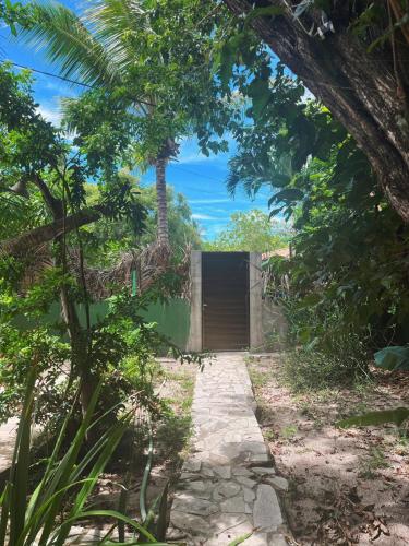 a house with a wooden door in the middle of a forest at MangoBrazil in Imbassai