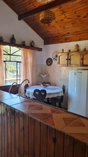 a kitchen with a table and a refrigerator in a room at Apartamentos Roncalli Monte Verde in Monte Verde