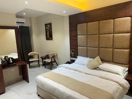 um quarto com uma cama grande e uma grande cabeceira. em Hotel Asha & Banquet em Bettiah