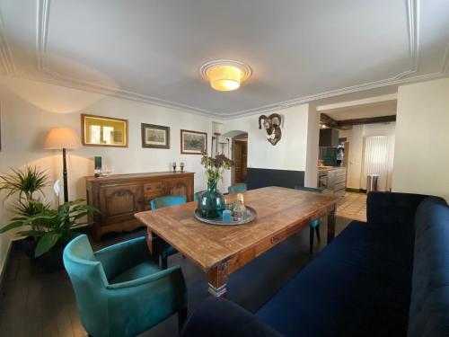 sala de estar con mesa de madera y sillas azules en Country house 'Un der Attert', en Boevange-sur-Attert