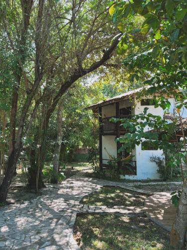 a building in the middle of a park with trees at MangoBrazil in Imbassai