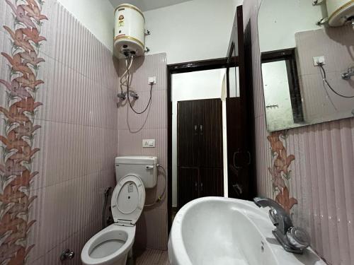 uma casa de banho com um WC, um lavatório e um espelho. em Marina trail em Dharamshala