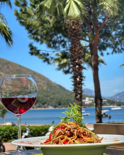 a plate of pasta and a glass of wine at Hotel Chateau de Ville in Marmaris