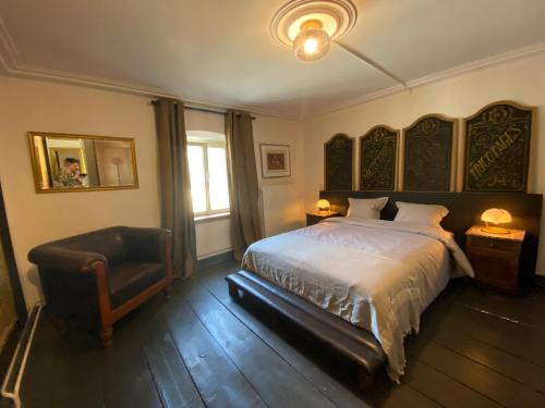 1 dormitorio con 1 cama, 1 silla y 1 ventana en Country house 'Un der Attert', en Boevange-sur-Attert
