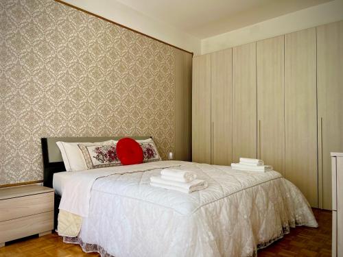 a bedroom with a white bed with a red pillow at Venice VIP Guest House in Mestre