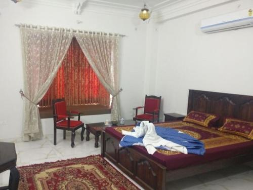a bedroom with a bed and a table and chairs at Tej Mahal Palace in Bandikui