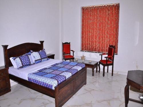 a bedroom with a bed and chairs and a table at Tej Mahal Palace in Bandikui