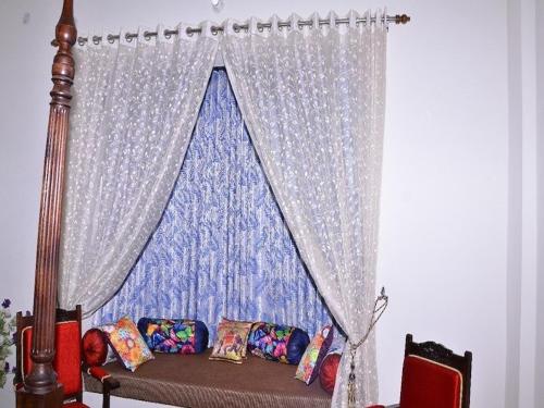 a room with a curtain and a couch in front of a window at Tej Mahal Palace in Bandikui