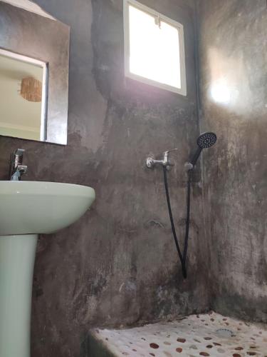a bathroom with a sink and a shower with a window at Résidence Tianay in Antananarivo
