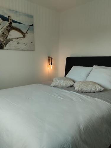 a white bed with two pillows on top of it at Gîte plage de Normandie - Asnelles plage du débarquement Gold Beach in Asnelles