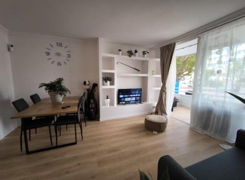 - un salon avec une table à manger et une horloge dans l'établissement Golf vila3, à San Miguel de Abona