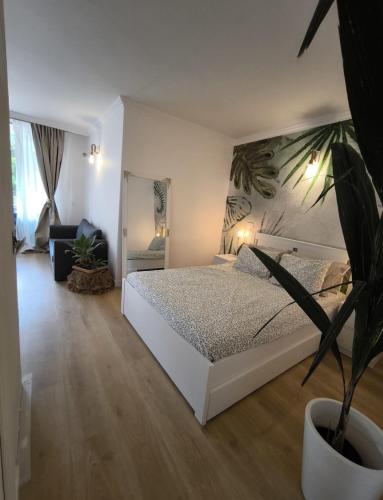 a bedroom with a white bed and a potted plant at Golf vila3 in San Miguel de Abona