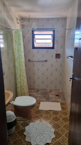 a bathroom with a toilet and a window at Apartamentos Roncalli Monte Verde in Monte Verde